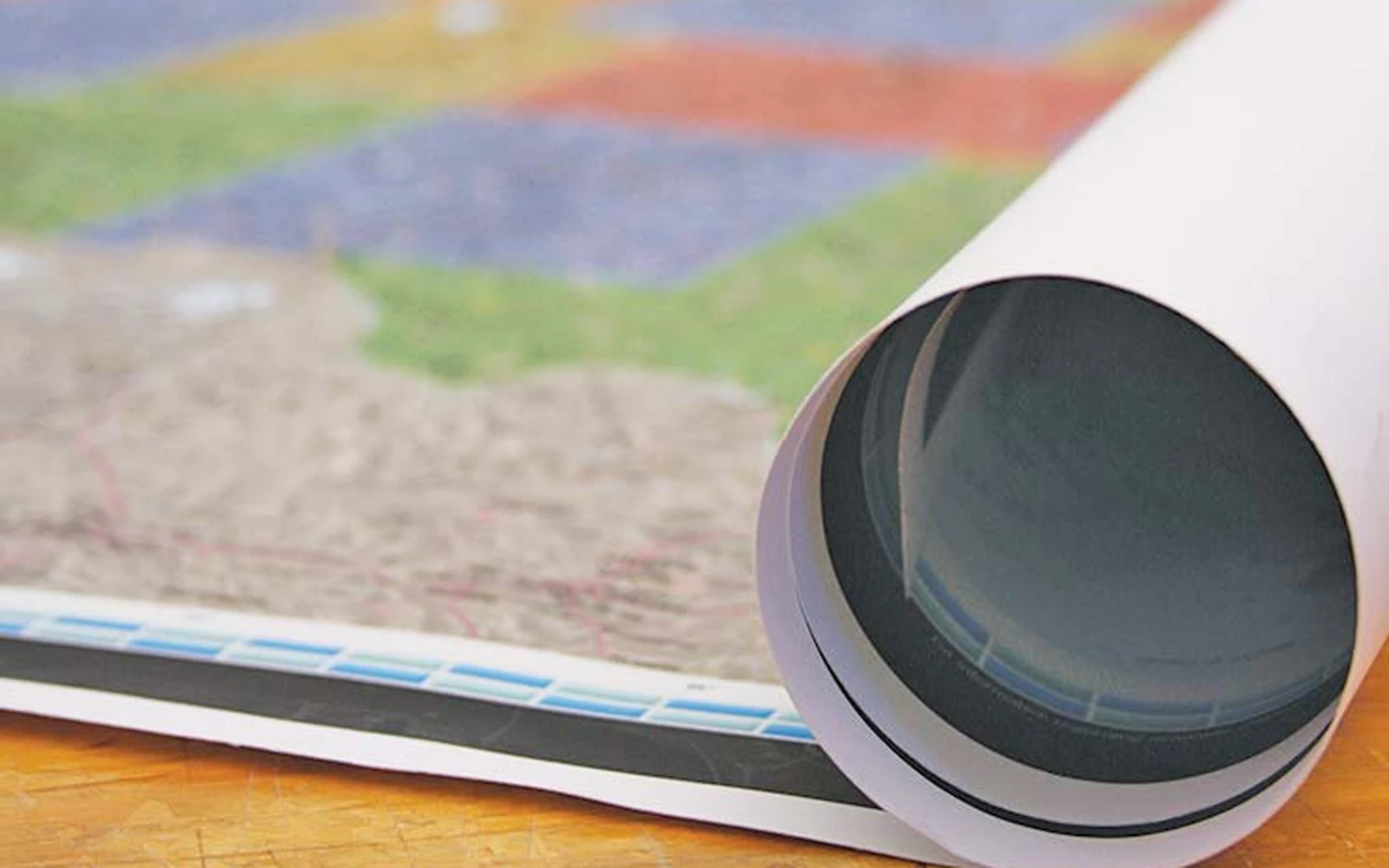 A rolled paper map beside the end of a shipping tube