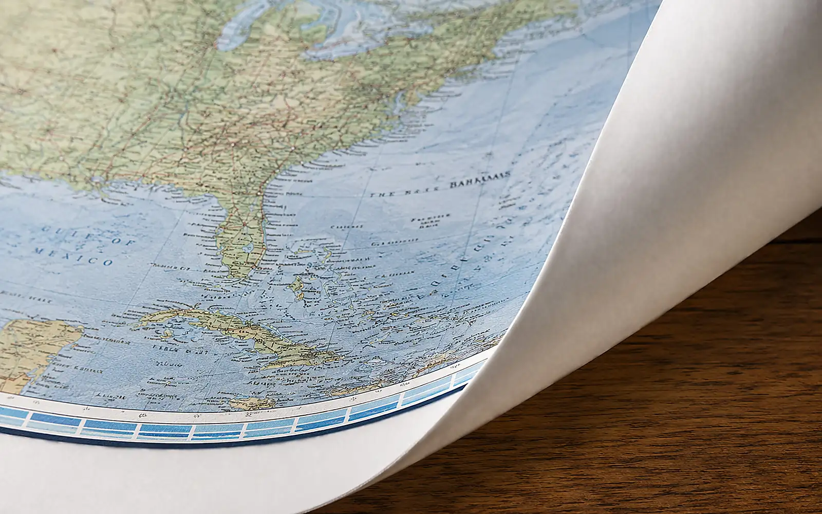 The corner of an unmounted paper map, curling gently away from the wall