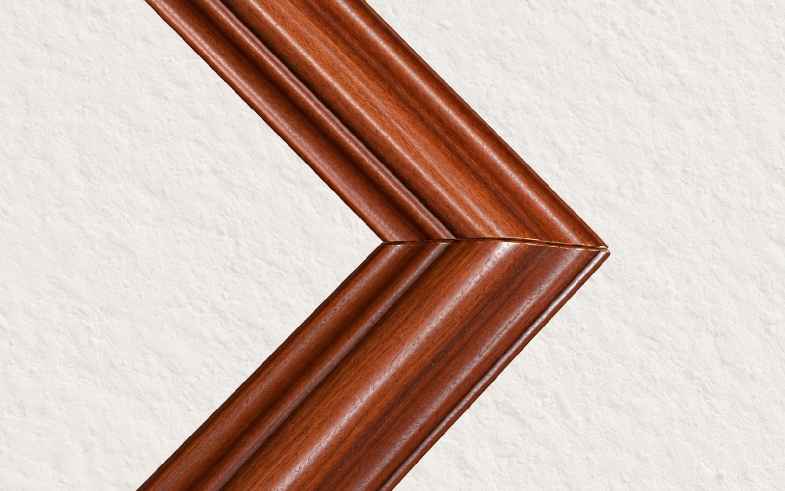 The mitred corner of a cherry stained wood frame