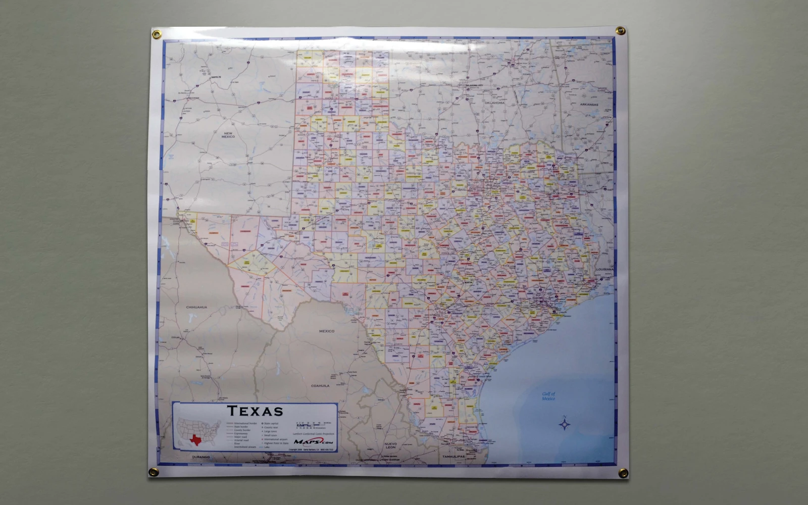 A Texas wall map hung flat by grommets at all four corners