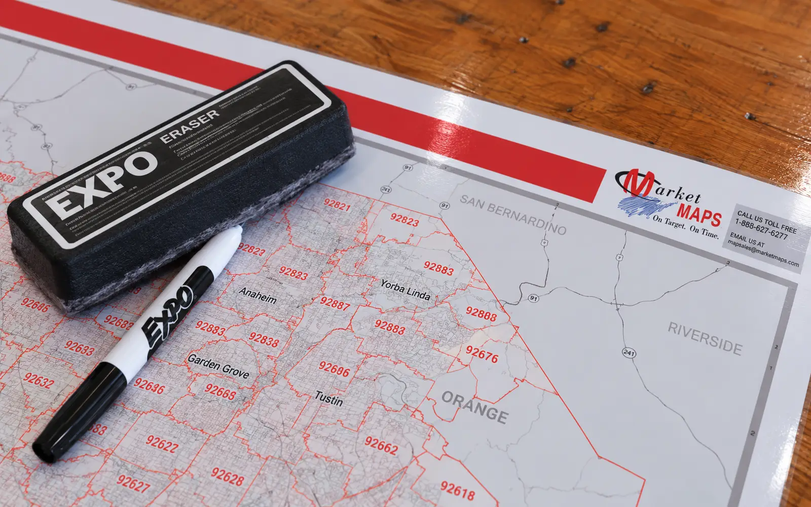 A glossy laminated map with a dry-erase marker and eraser resting on it