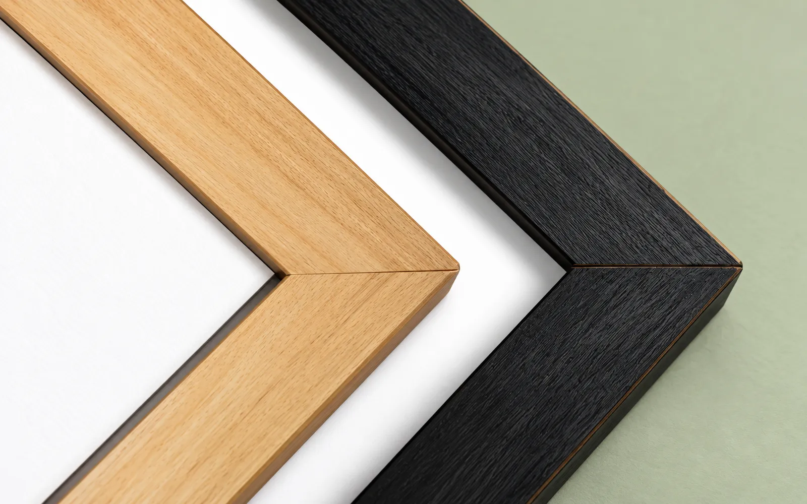 Three plain wood frame corners side by side: natural, black and grey
