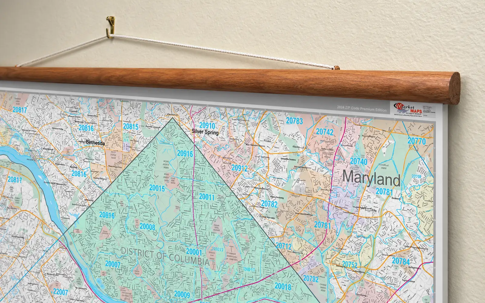 A mounted map hung from a hardwood rail and cord on a picture hook