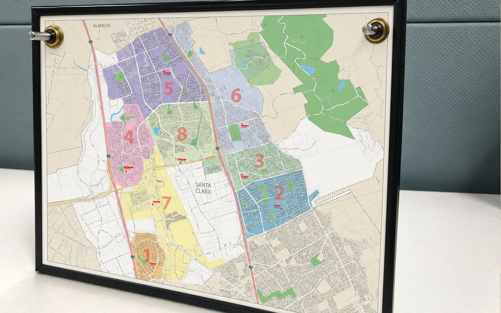 A framed city map with numbered territories shaded in colour