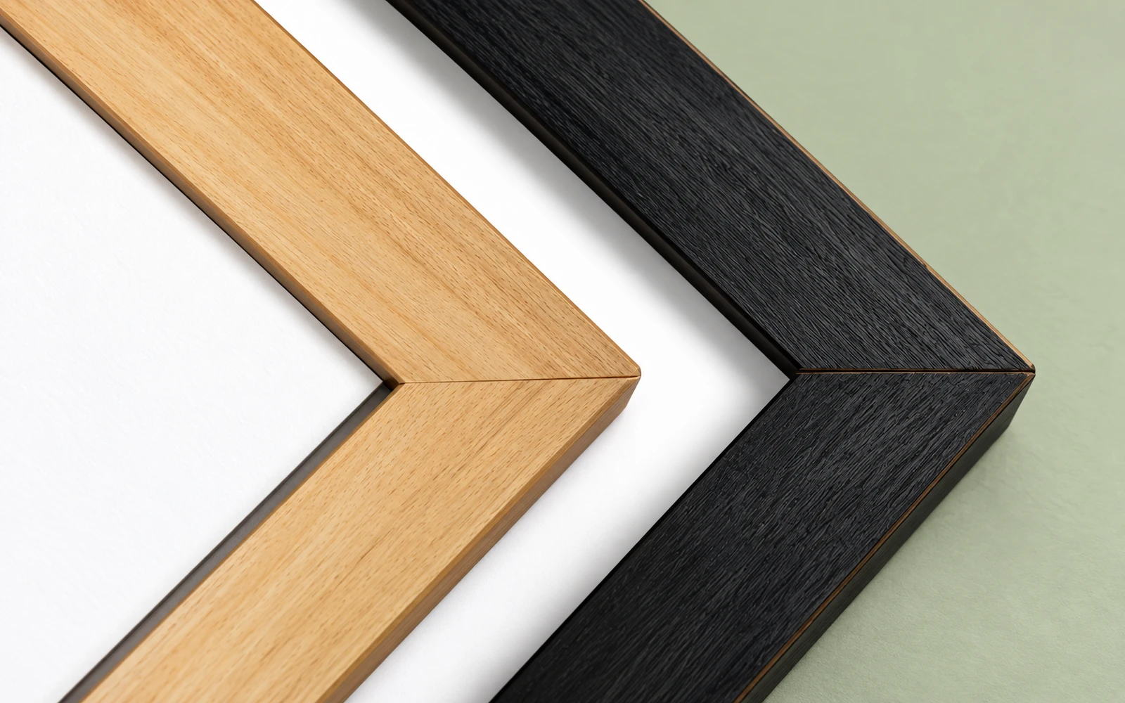 Two wood frame corner samples side by side, one unfinished pine and one black