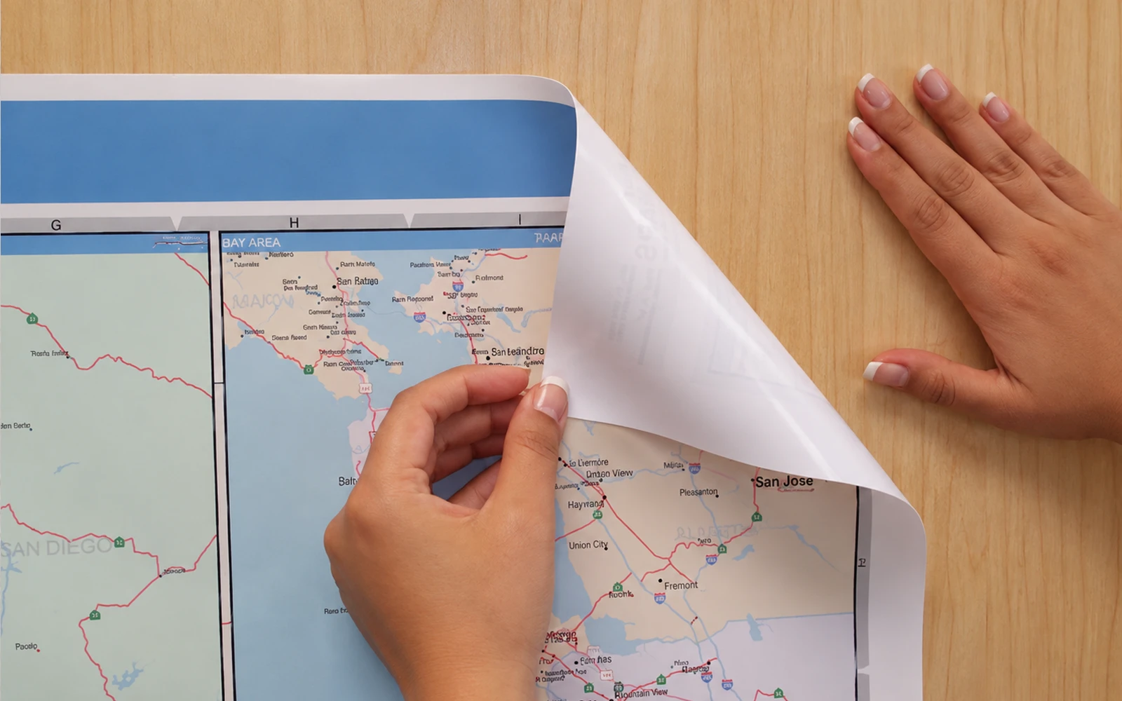 A ReSticker map being peeled back from a wood panel