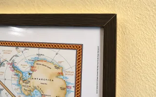 A map in a plain black wood frame, hung flat against the wall